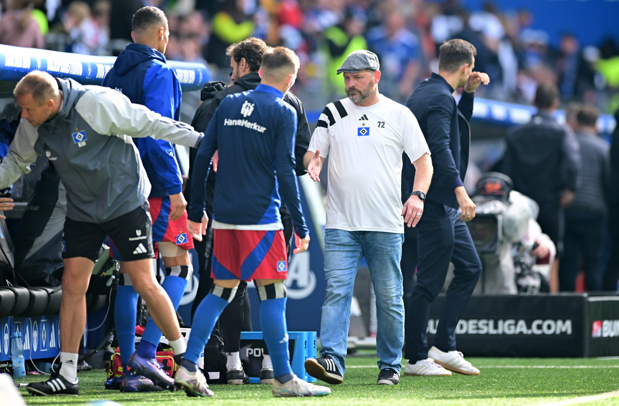 Steffen Baumgart klatscht nach dem HSV-Spiel an der Bank mit den Profis ab