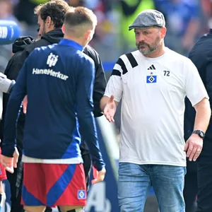 Steffen Baumgart klatscht nach dem HSV-Spiel an der Bank mit den Profis ab