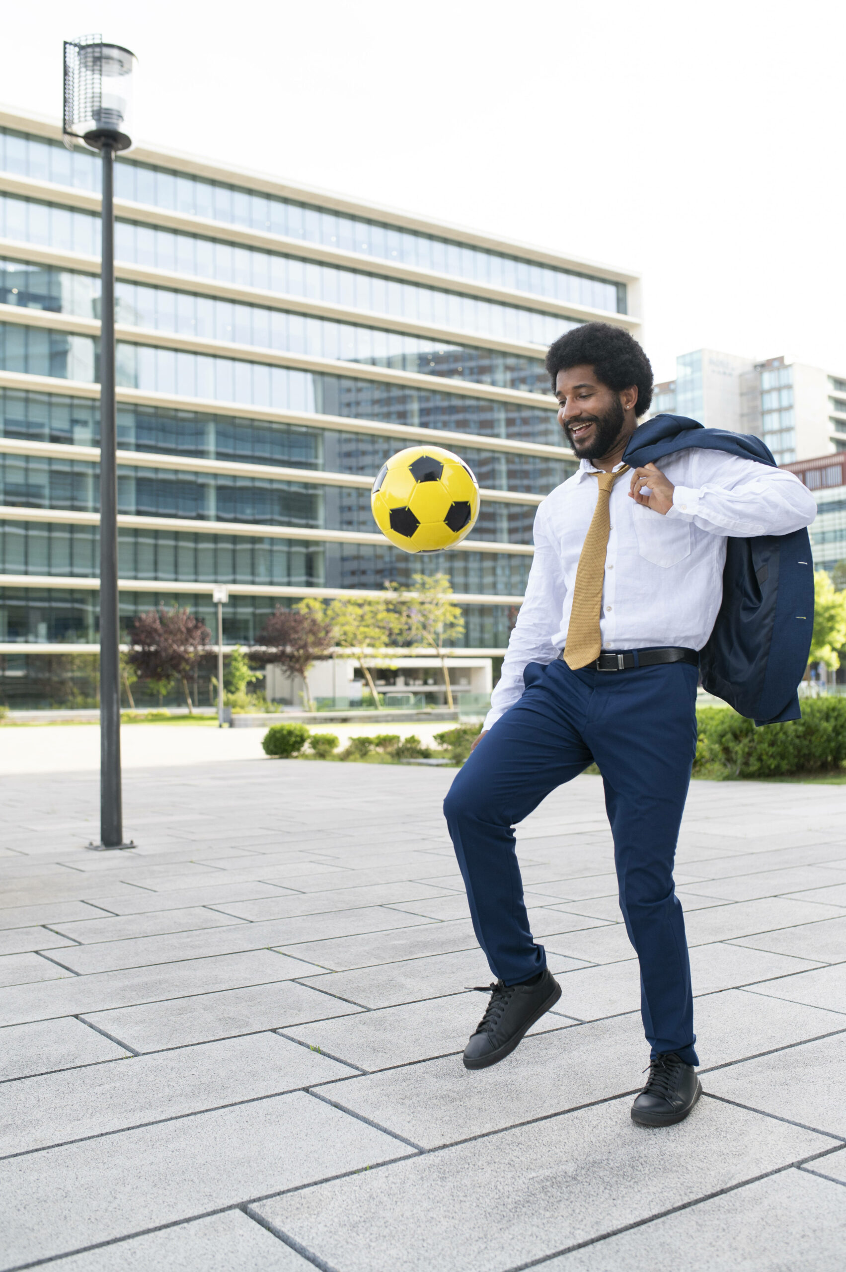 Geschäftsmann spielt mit Fußball.