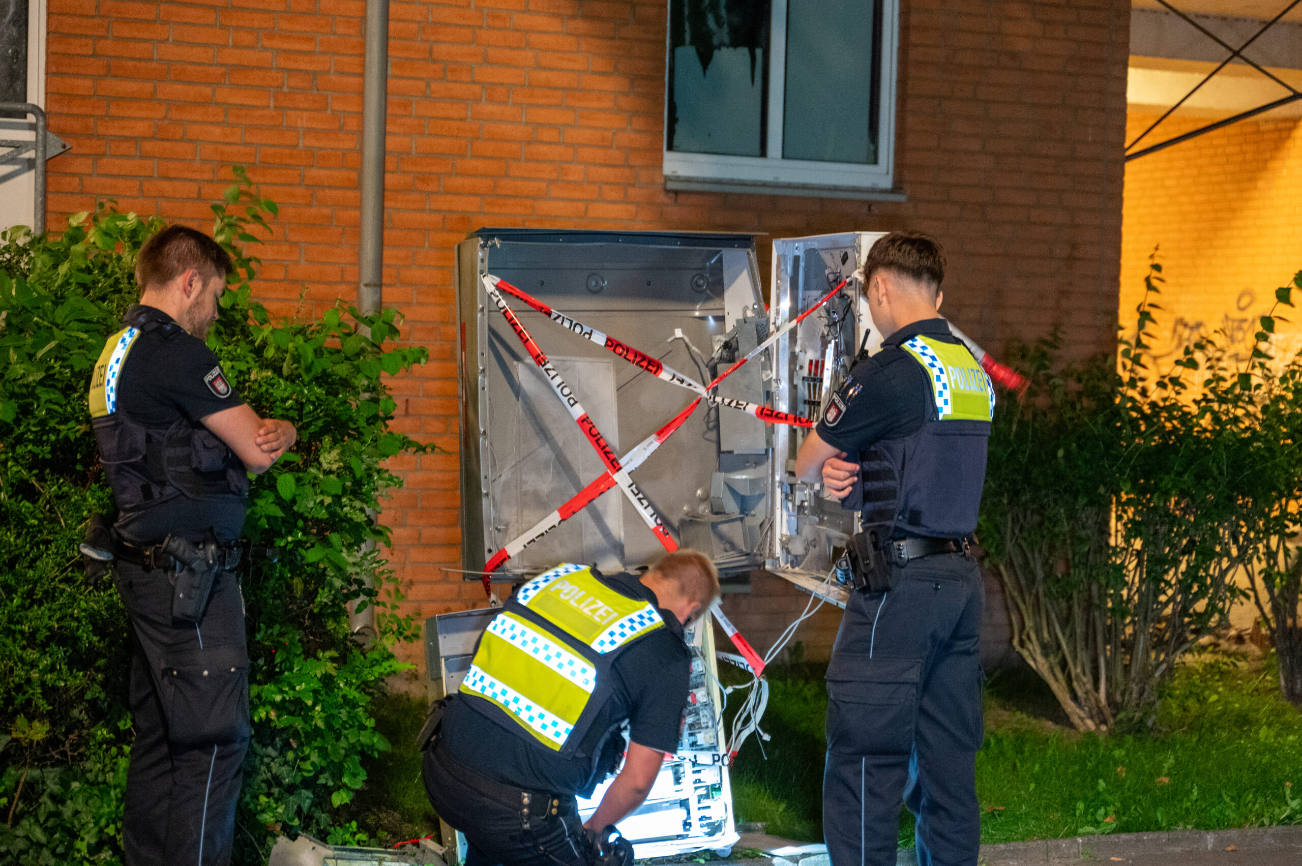 Polizisten untersuchen den gesprengten Zigarettenautomaten auf der Von-Scheliha-Straße.