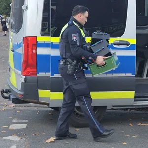 Polizisten tragen Beweismittel aus dem Verein in Jenfeld.