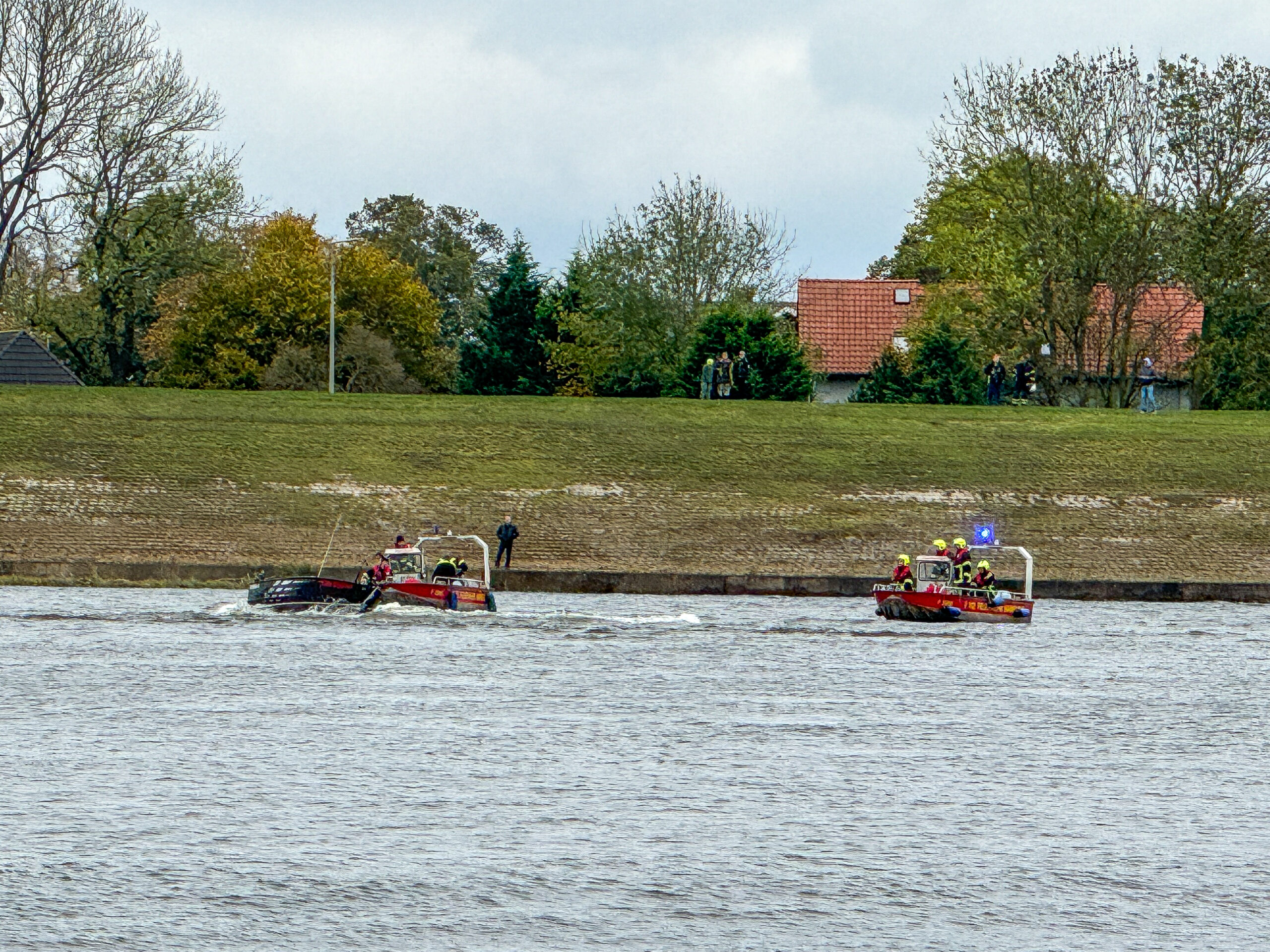 Polizeiboote auf der Elbe, im Hintergrund ein Deich