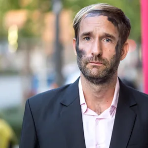 Junger Mann mit schwarzer Farbe im Gesicht