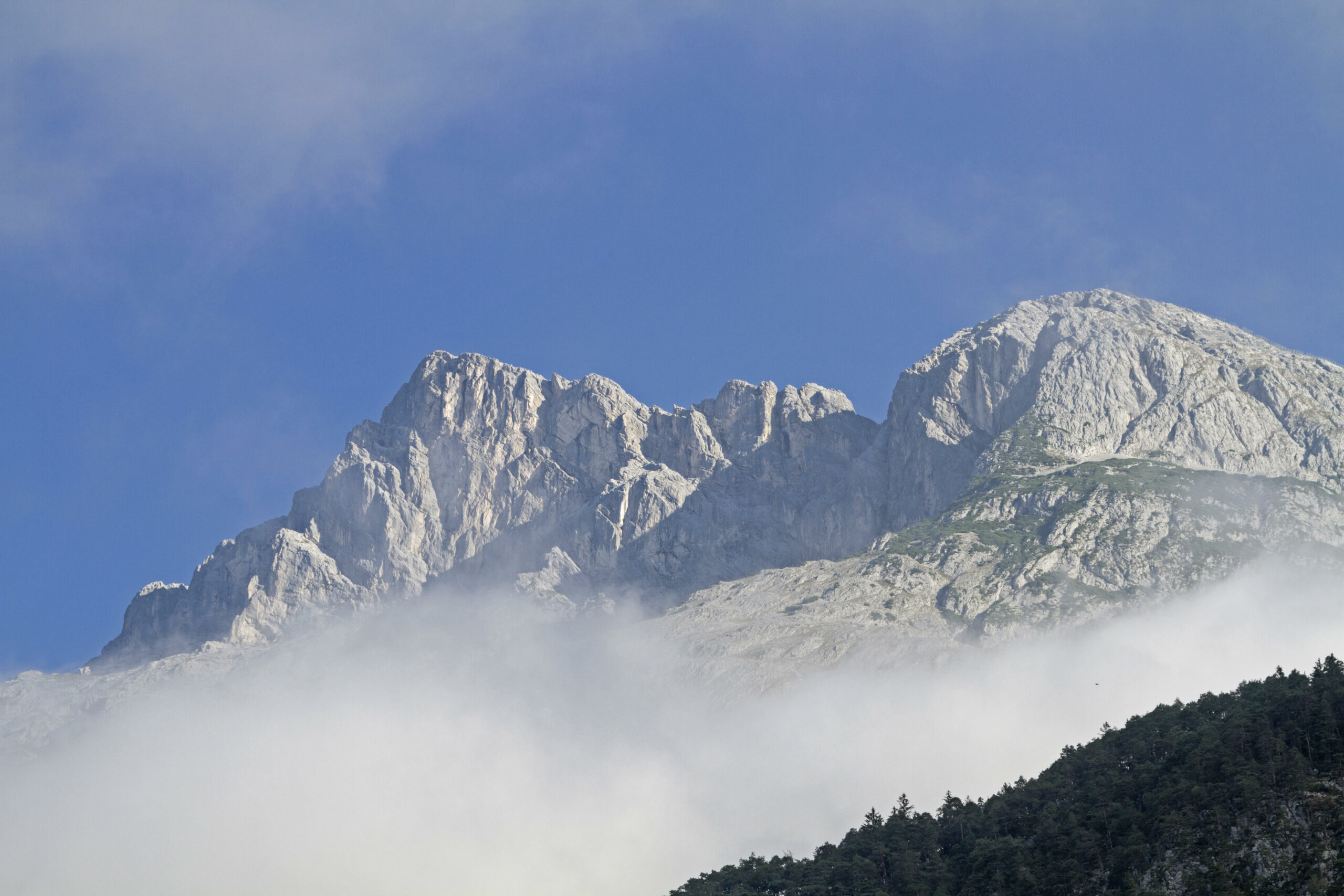 Zwei Berggipfel ragen aus Wolken