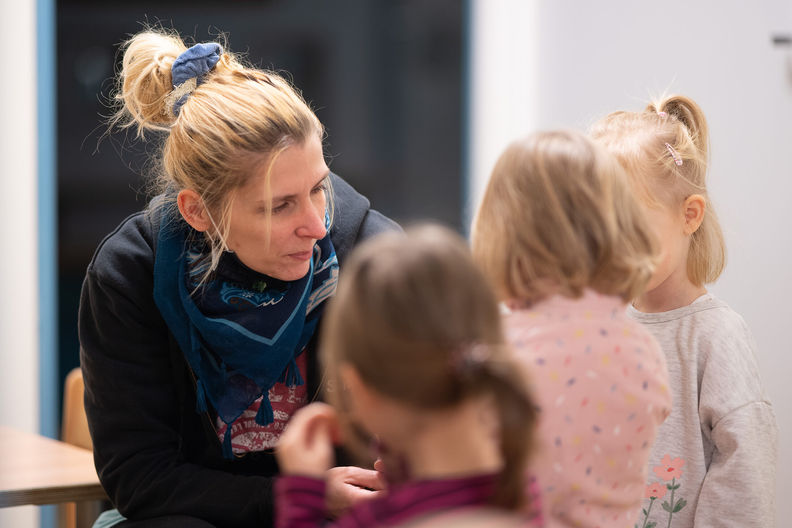 Eine Erzieherin spricht mit Kindern. In Kindertagesstätten fehlt es an Fachkräften.