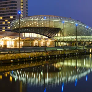 Ein futuristisches Gebäude am Wasser im Dunkeln