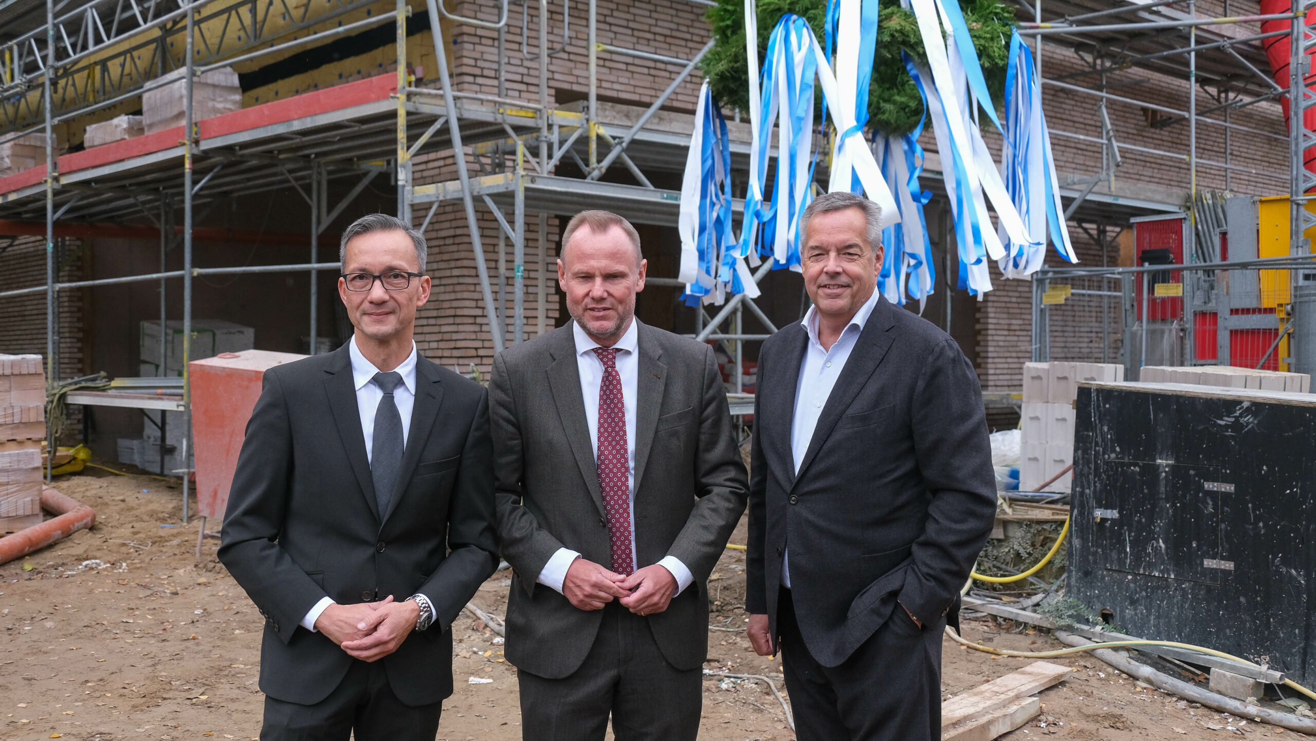 Polizeipräsident Falk Schnabel, Innensenator Andy Grote und Jan Zunke von der Sprinkenhof GmbH (v.l.) beim Richtfest in Winterhude.