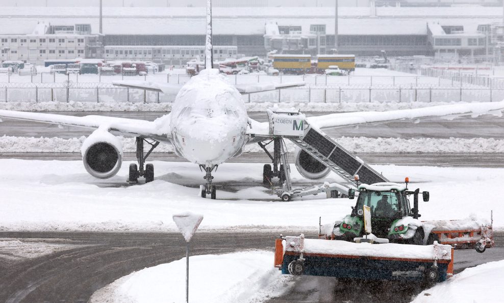 Ein Flugzeug ist komplett eingeschneit am Flughafen.