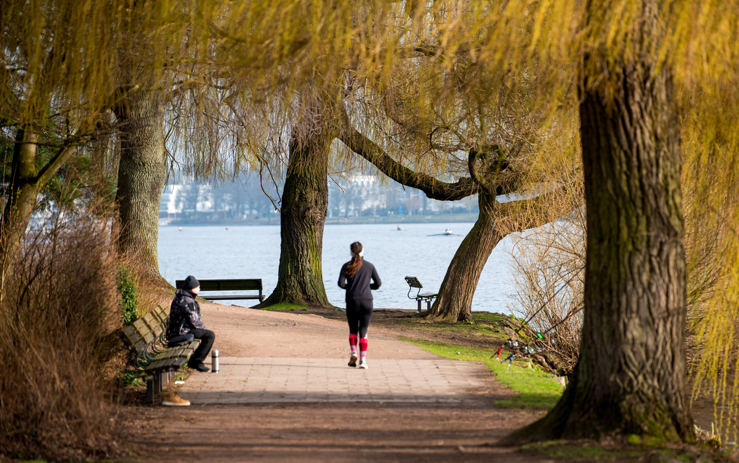 Eine Frau joggt entlang der Außenalster