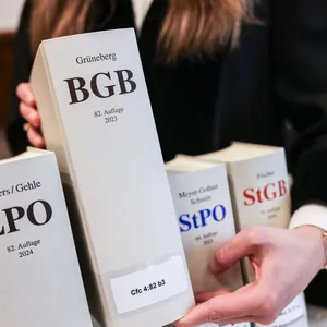 Eine Richterin hält im Gerichtssaal das Bürgerliches Gesetzbuch (BGB) in der Hand.