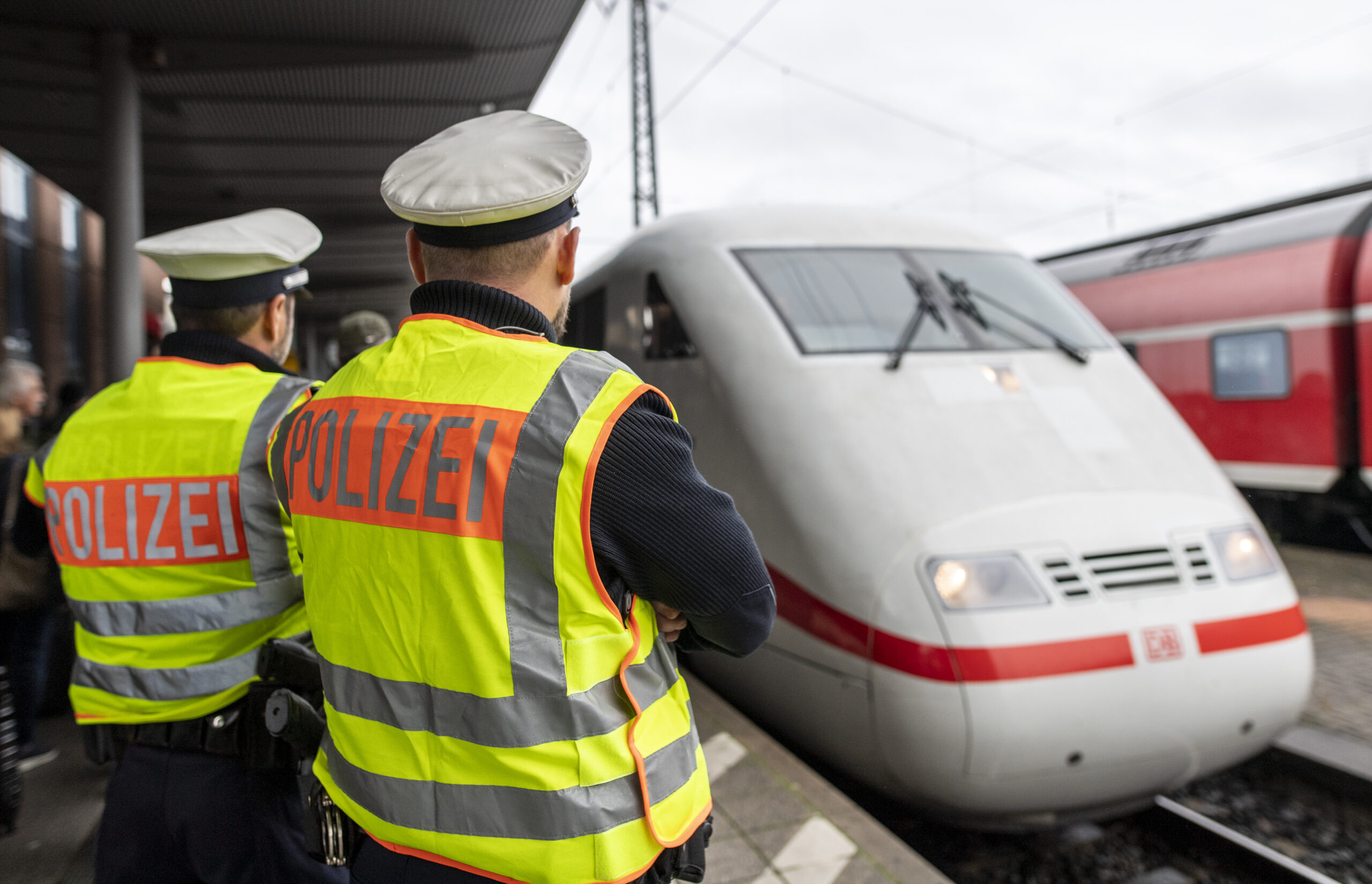 Zwei Beamte der Bundespolizei beobachten am Hauptbahnhof die Einfahrt eines ICE