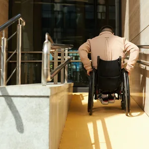 Ein Mann in einem Rollstuhl fährt eine Rampe hoch