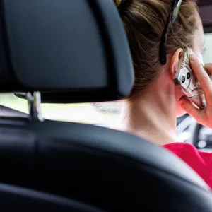 Autofahrerin mit Handy am Ohr