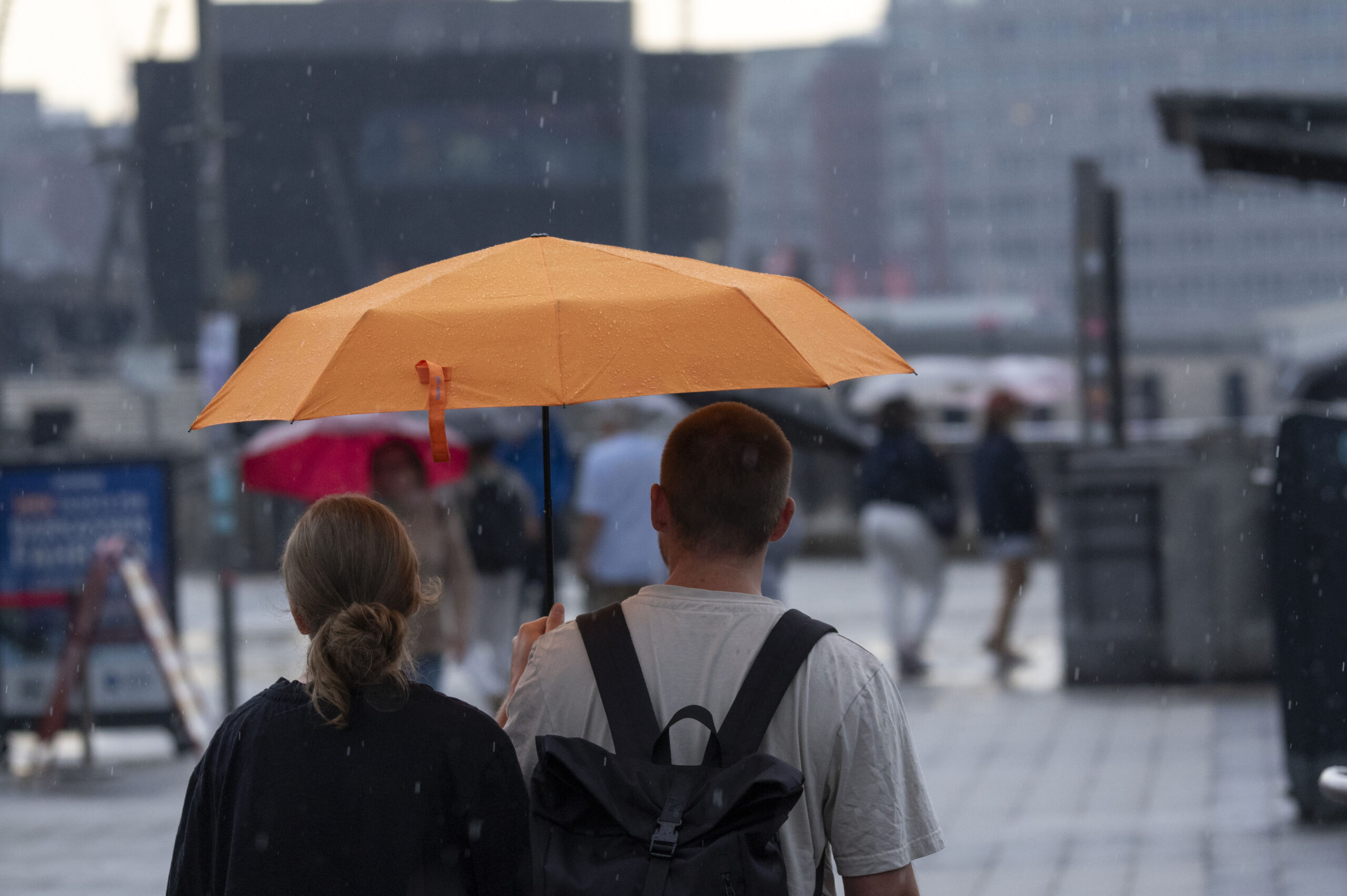 Paar mit orangefarbenem Regenschirm