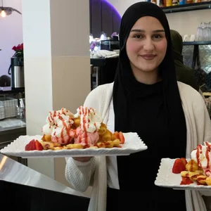 Sumeja Zumberi hält zwei Teller mit Waffeln in der Hand.
