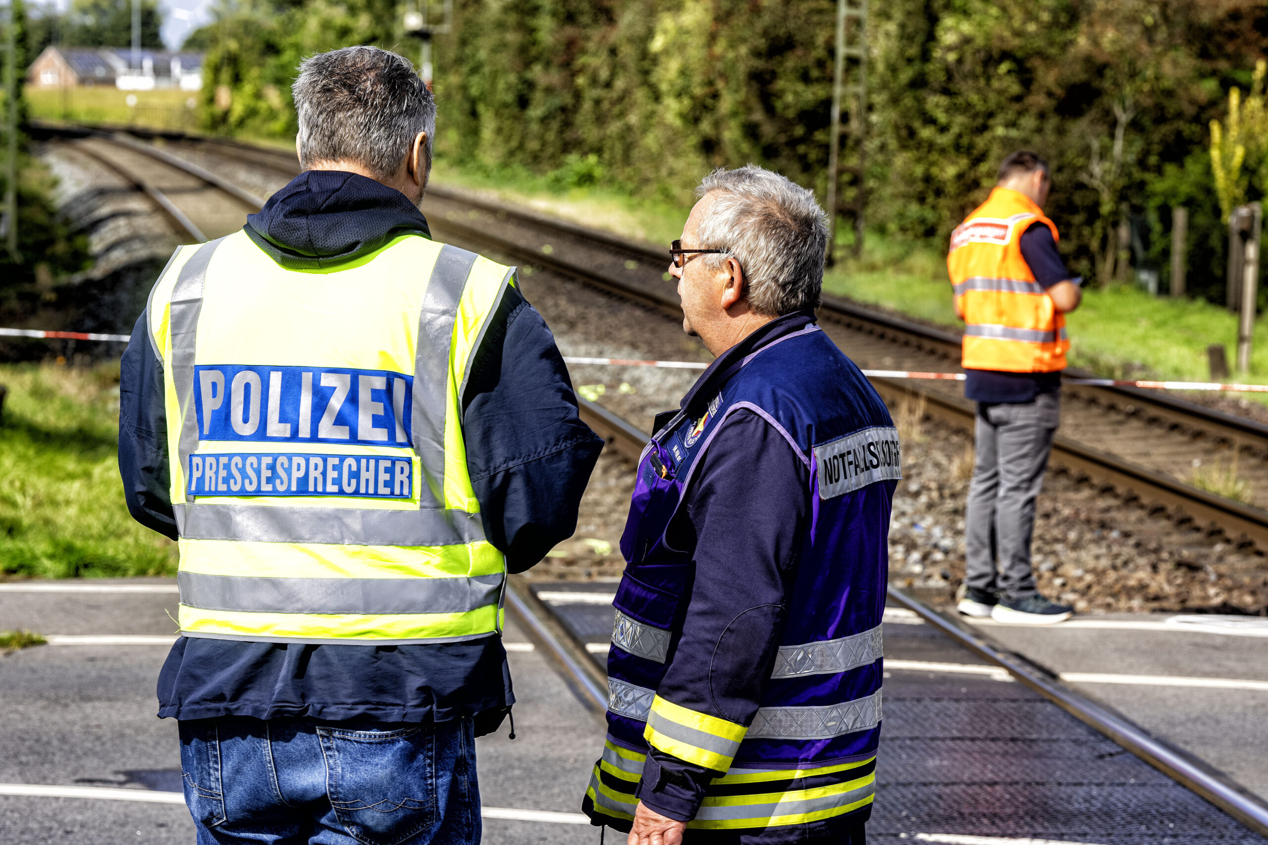 Polizei und Einsatzkräfte stehen an einem Bahngleis.