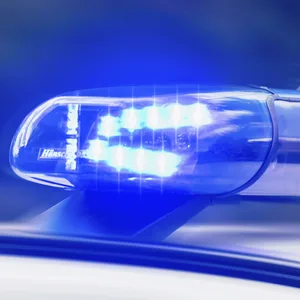 Das Foto zeigt das Blau-Licht auf dem Dach eines Polizeiautos bei Nacht
