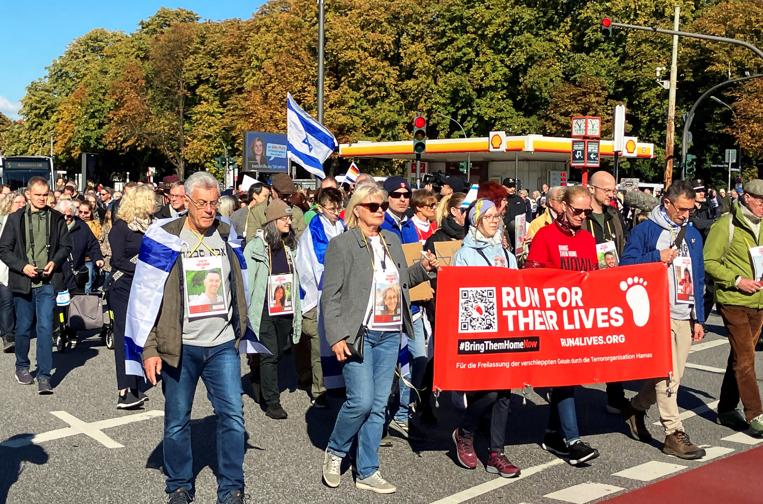 Teilnehmer halten einen Banner mit der Aufschrift „Run for their lives“ in der Hand.