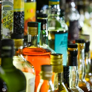 Mehrere Dutzend volle Flaschen Alkohol stehen aufgereiht in mehreren Reihen