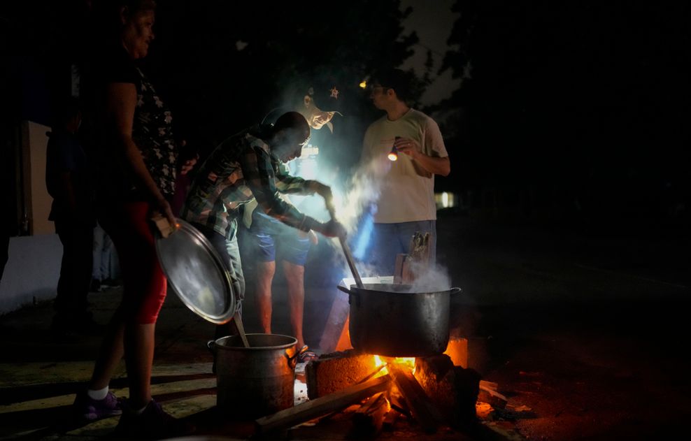 Während eines Stromausfalls nach dem Ausfall eines großen Kraftwerks in Havanna bereiten Bewohner eine Suppe über einem offenen Feuer zu.