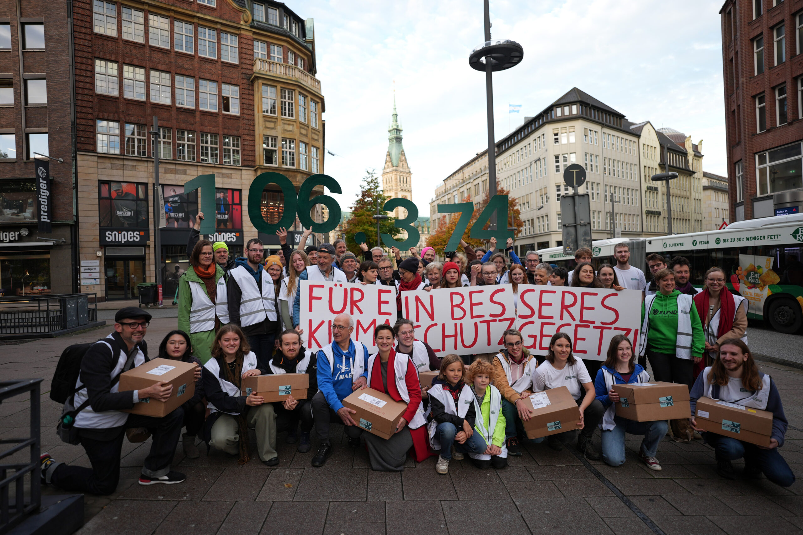 Aktivisten des Volksbegehrens „Hamburger Zukunftsentscheid“ stehen am Montag vor der Unterschriften-Übergabe auf der Mönckebergstraße in der Innenstadt.