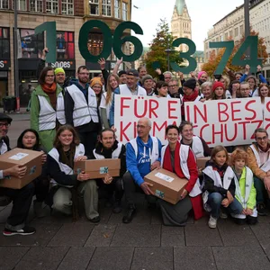 Aktivisten des Volksbegehrens „Hamburger Zukunftsentscheid“ stehen am Montag vor der Unterschriften-Übergabe auf der Mönckebergstraße in der Innenstadt.