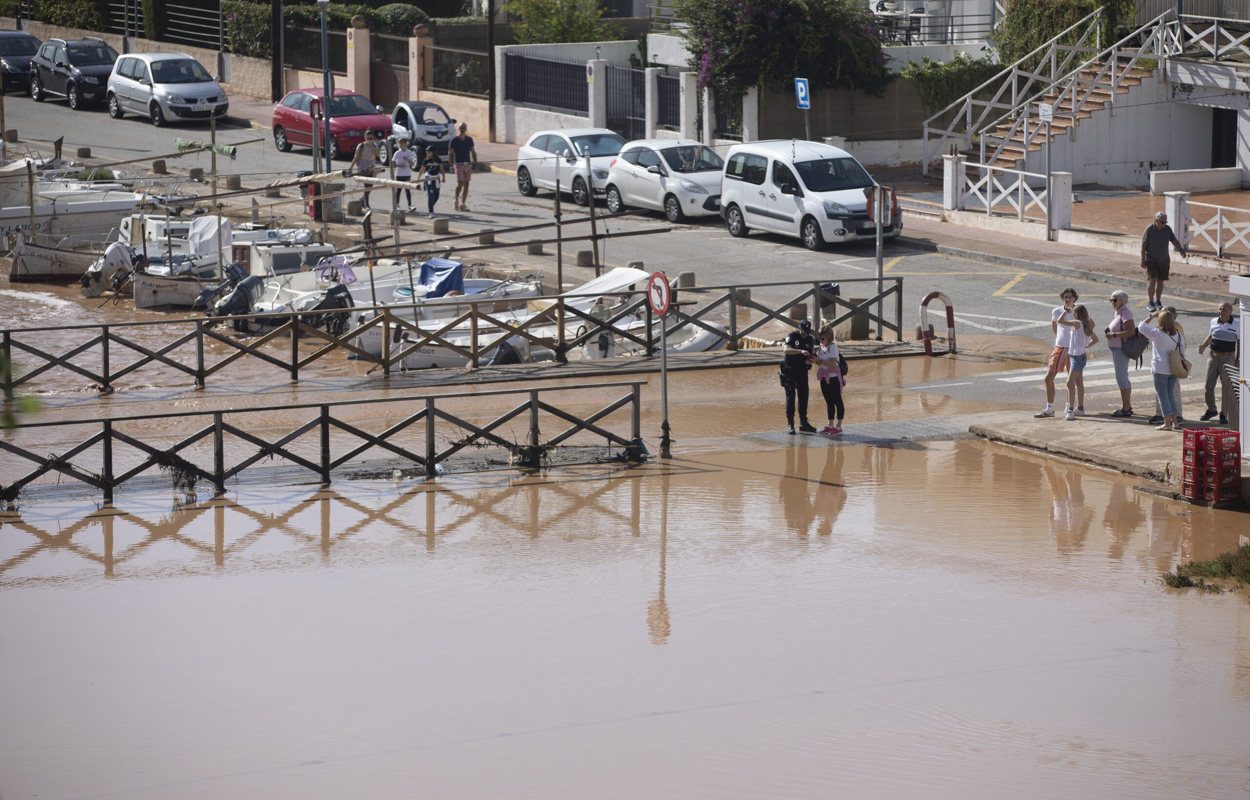 Überflutete Straße in Porto Cristo auf Mallorca ist überflutet. Menschen stehen im Wasser, im Hintergrund sind Autos.