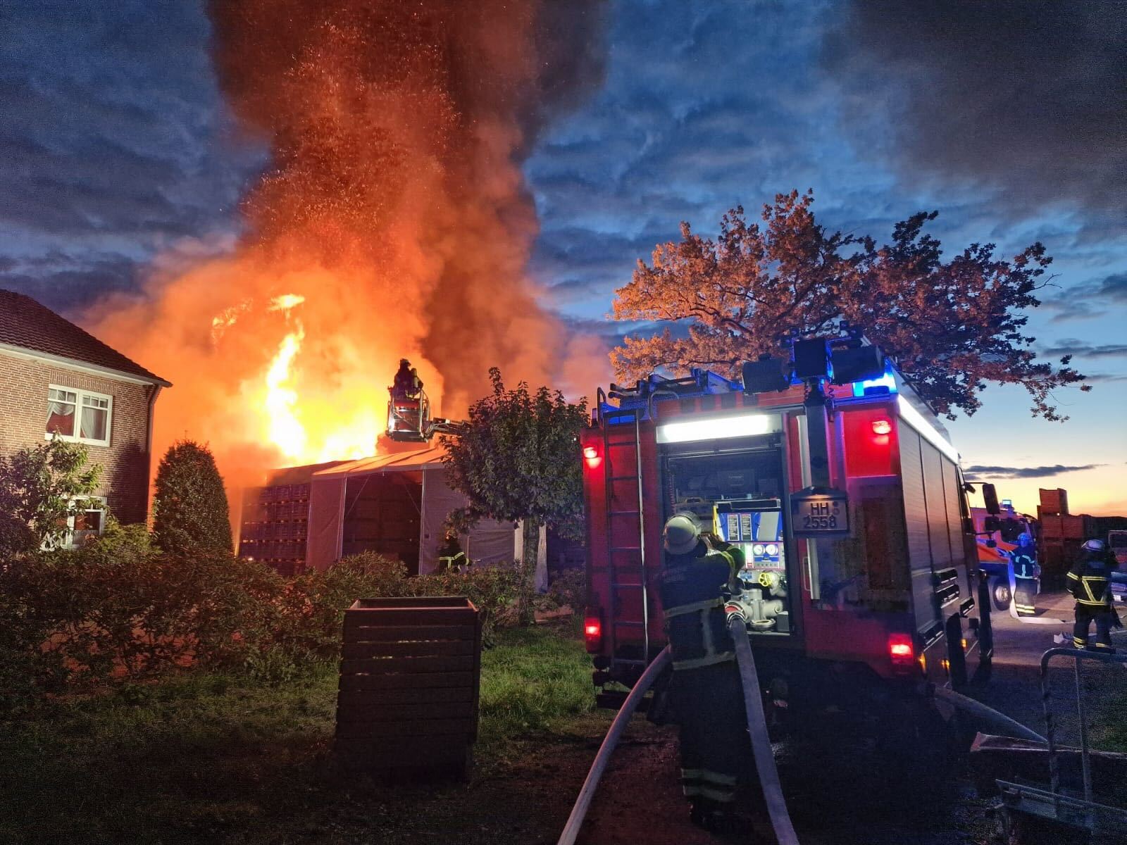 Feuerwehrauto vor hohen Flammen