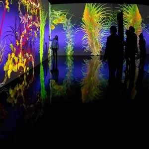 Menschen stehen ineinem dunklen Raum, wo eine Kunst-Installation zu sehen ist.