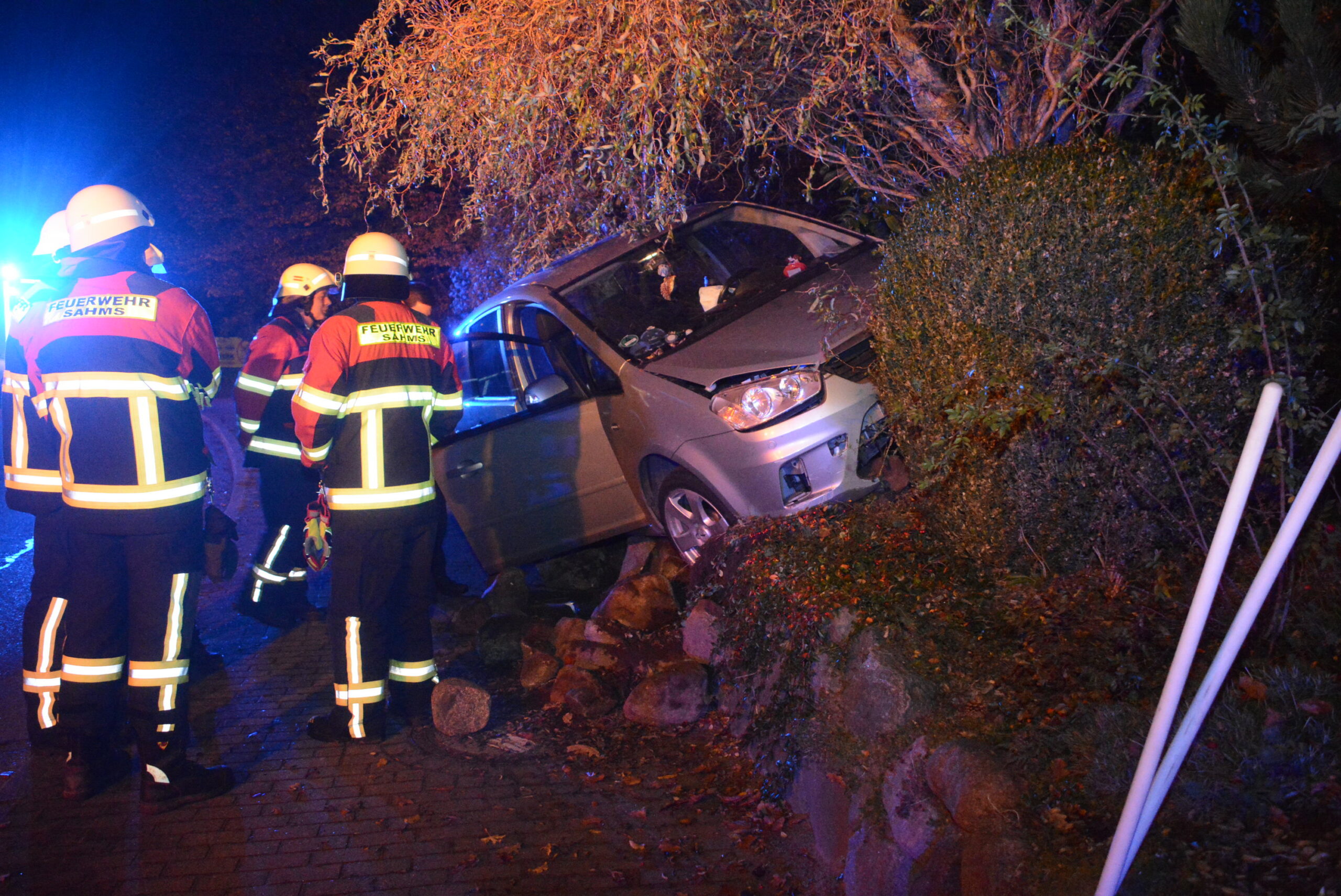 Der silberne Ford kam auf einer Steinmauer zum Stehen.