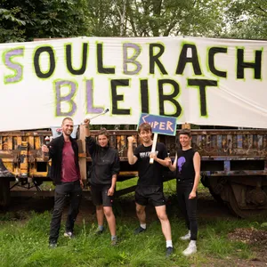 Menschen vor einem Plakat „Soulbrache bleibt“
