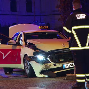 Rettungskräfte an einem zerdellten Taxi