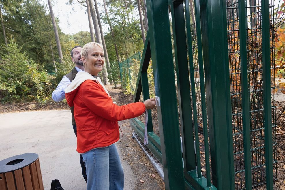 Stephanie von Berg (Grüne) schließt das Rolltor zum Waldspielplatz auf.