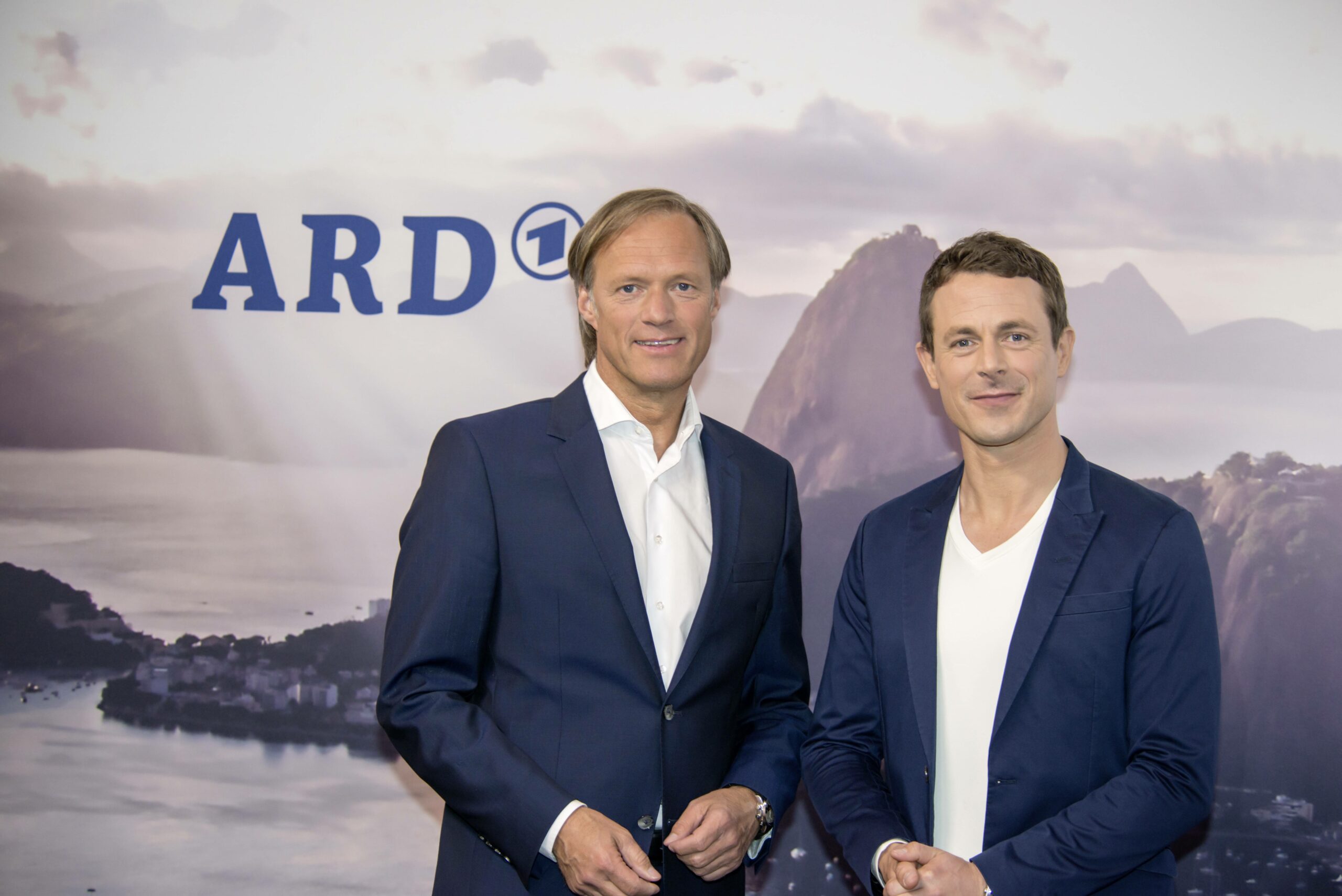 Gerhard Delling und Alexander Bommes vor einer ARD-Wand