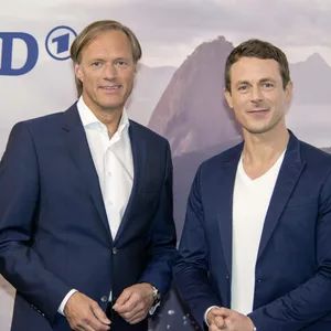 Gerhard Delling und Alexander Bommes vor einer ARD-Wand