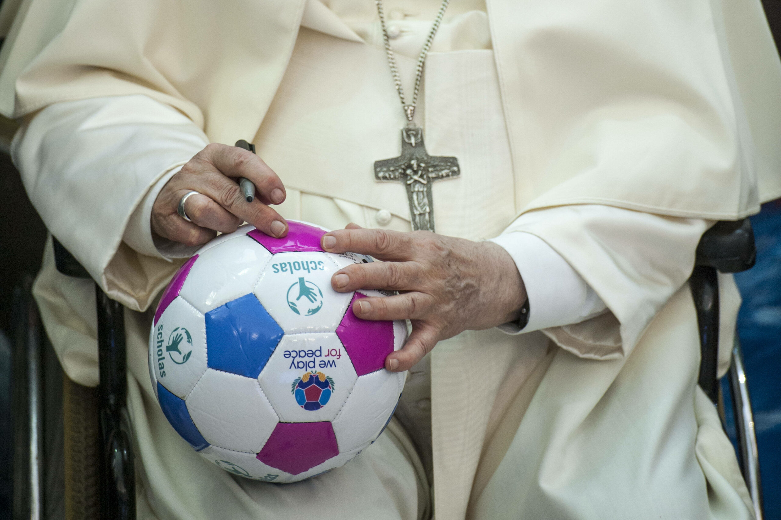 Der Papst mit einem Ball und einem Stift in der Hand