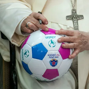 Der Papst mit einem Ball und einem Stift in der Hand
