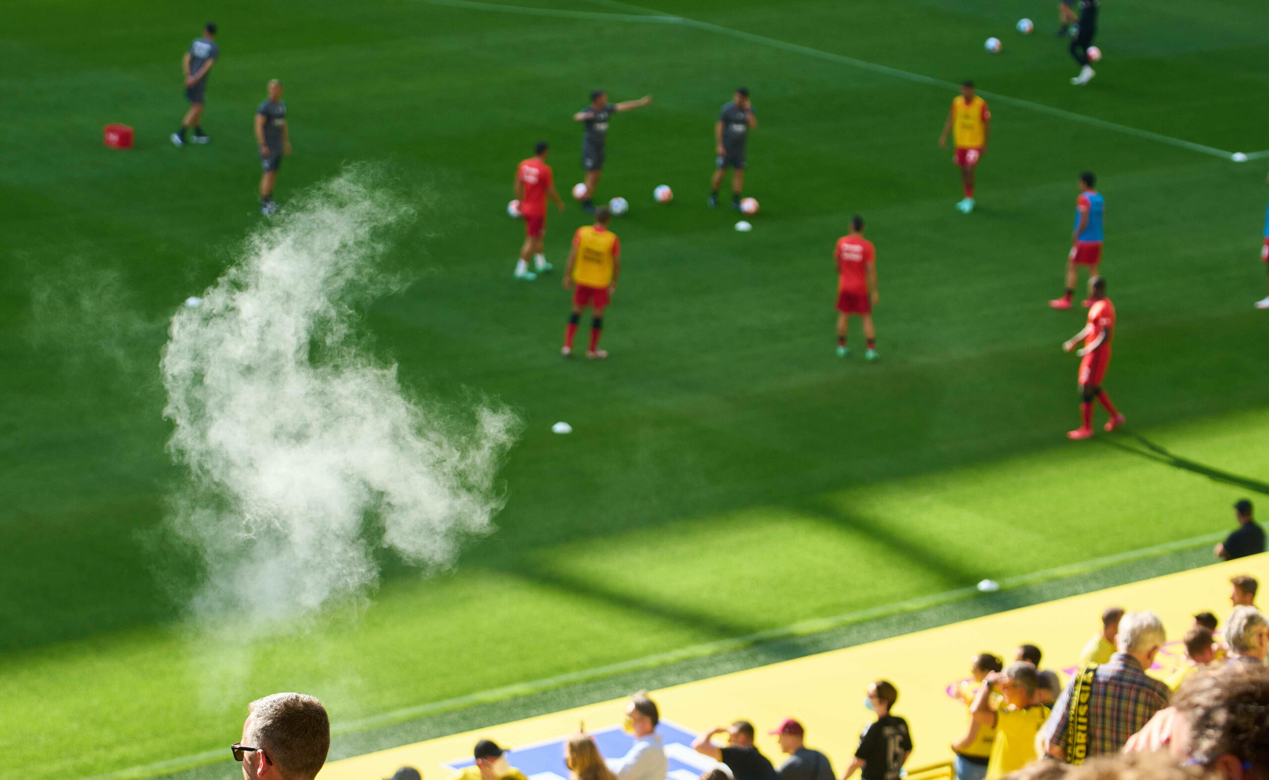 Zigarettenrauch steigt von der Tribüne auf