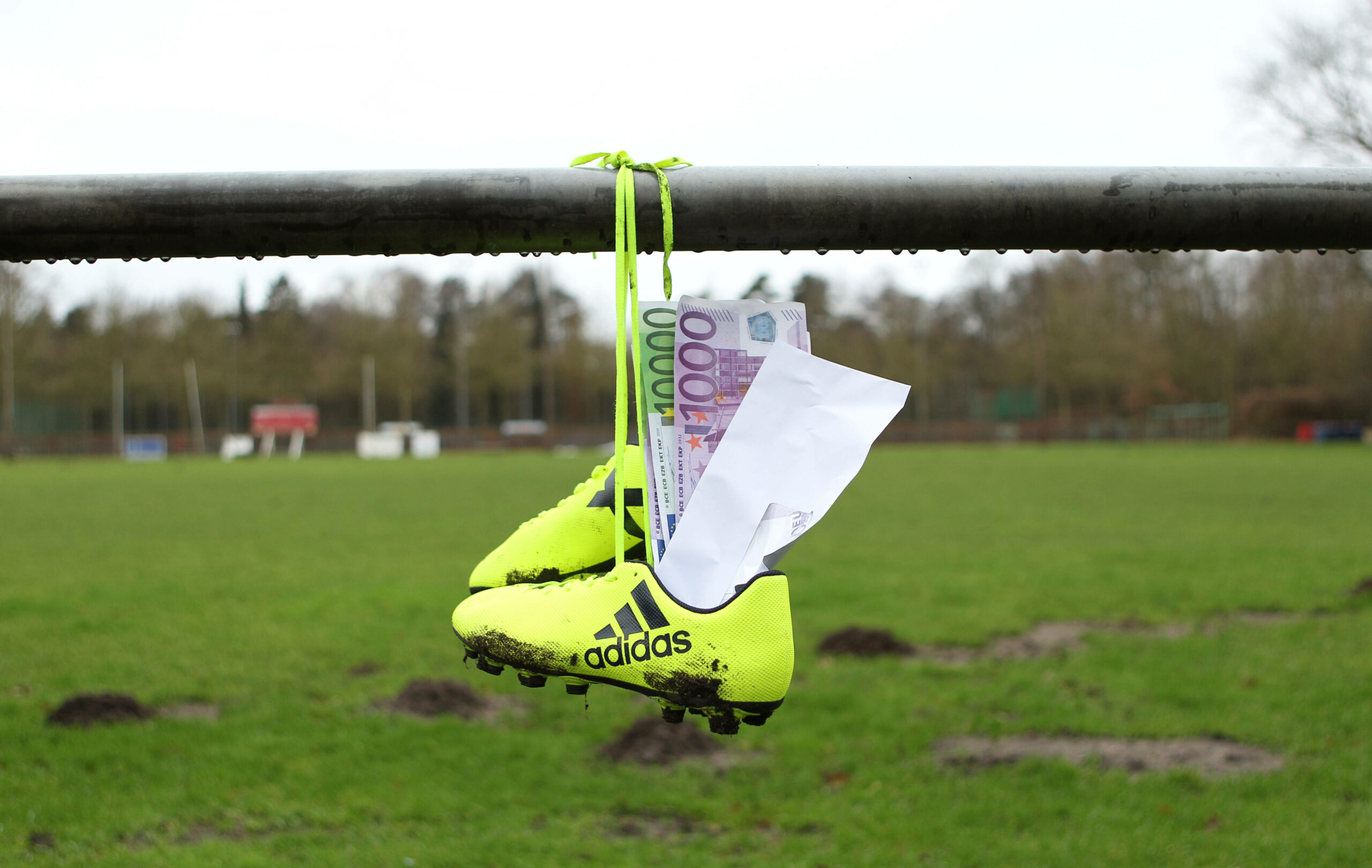 Briefumschlag mit Geldscheinen steckt in Fußballschuhen