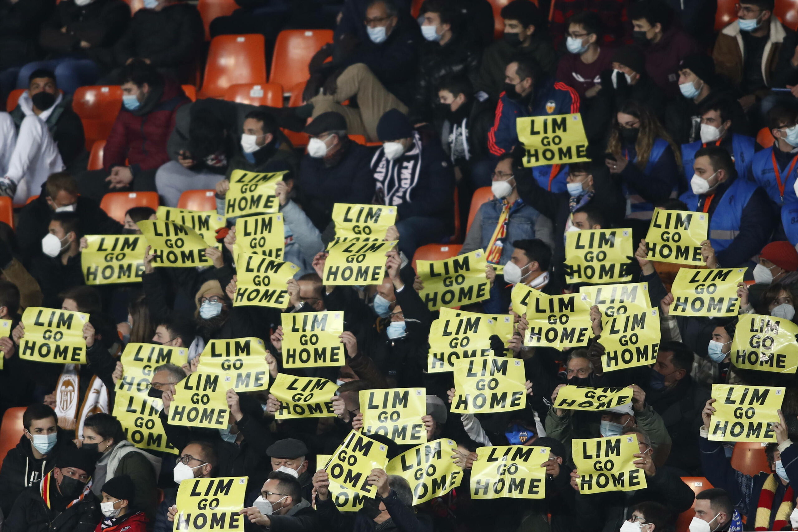 Fans halten Poster mit der Aufschrift „Lim go home“ nach oben