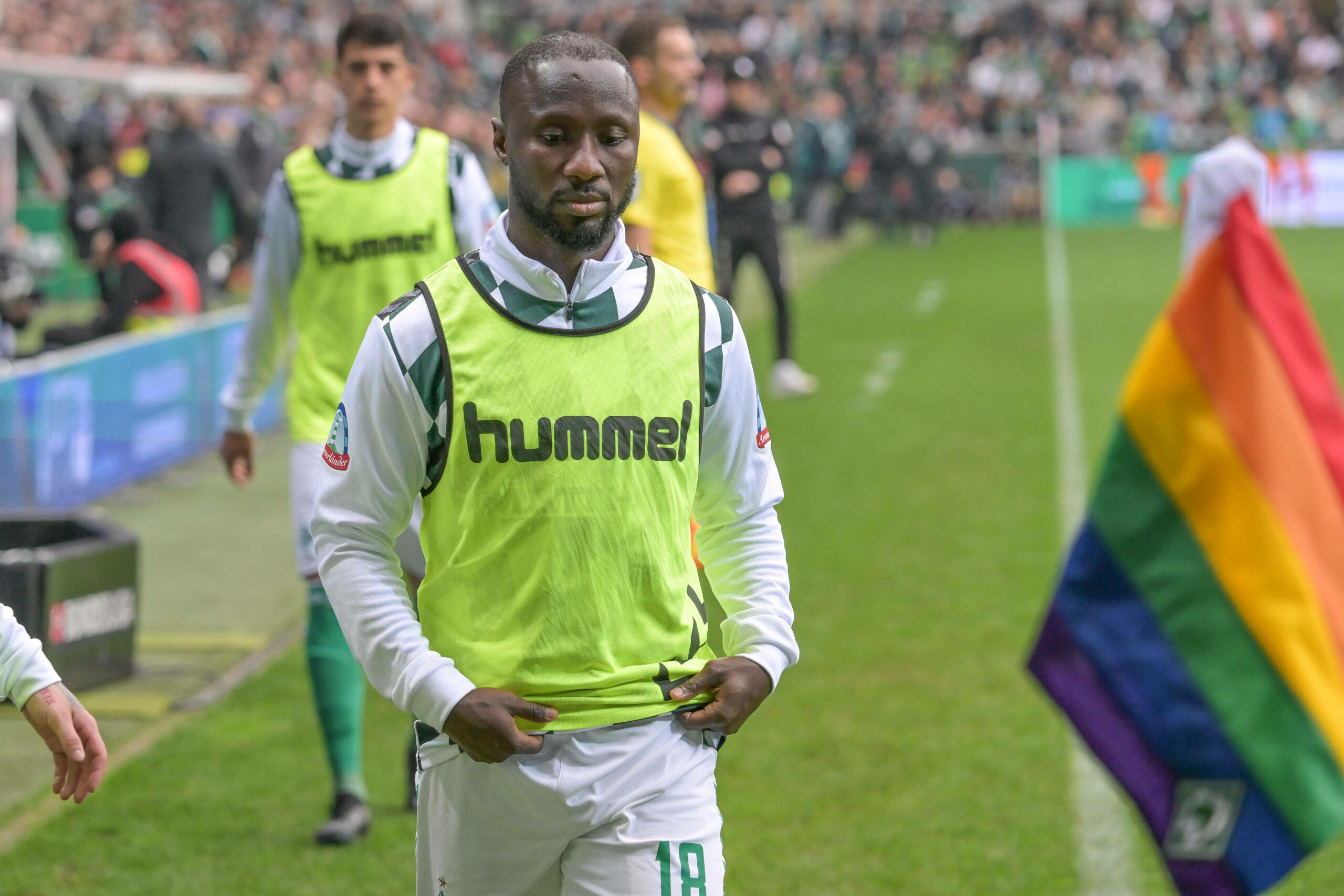 Werder Bremens Naby Keita geht mit Laibchen an der Seitenlinie des Weserstadions entlang