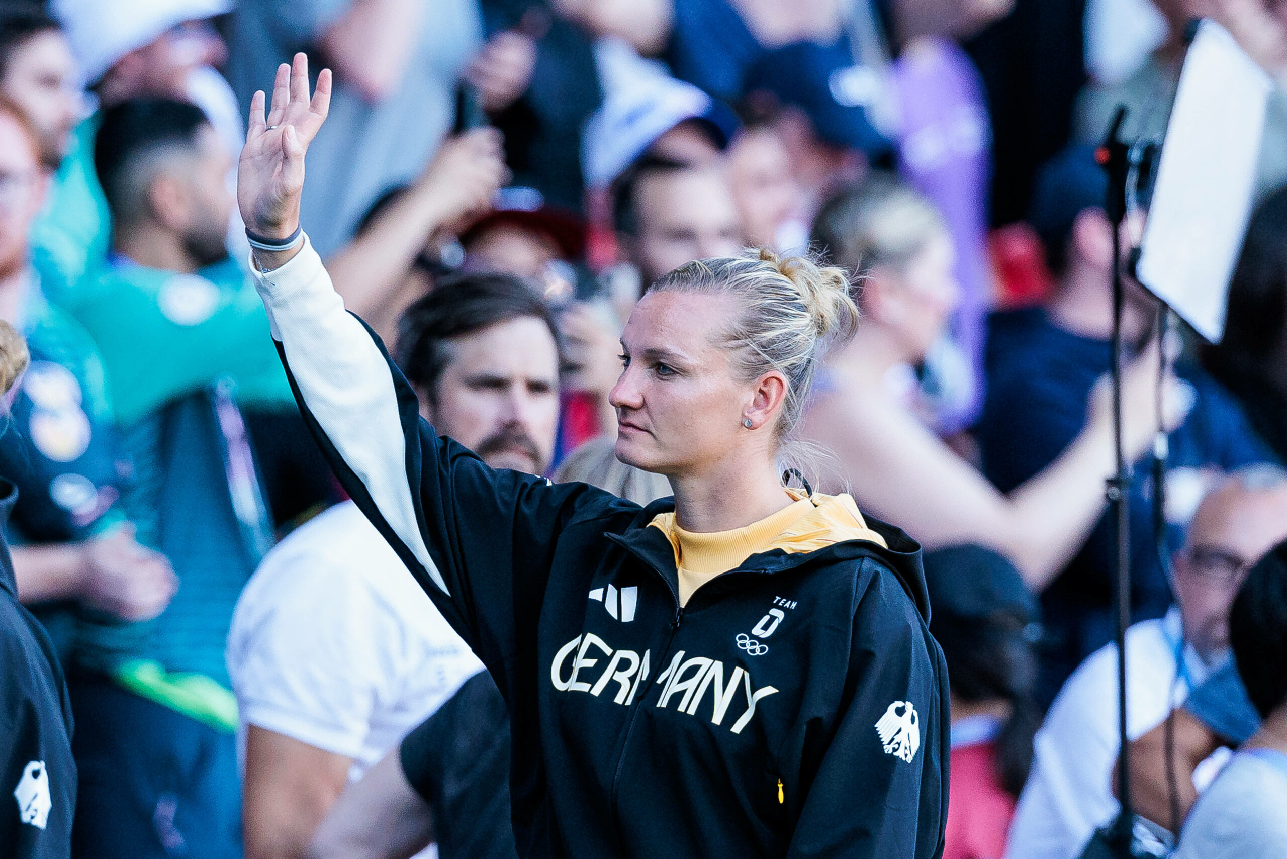 Alexandra Popp winkt in Richtung Fans bei der olympischen Siegerehrung in Paris