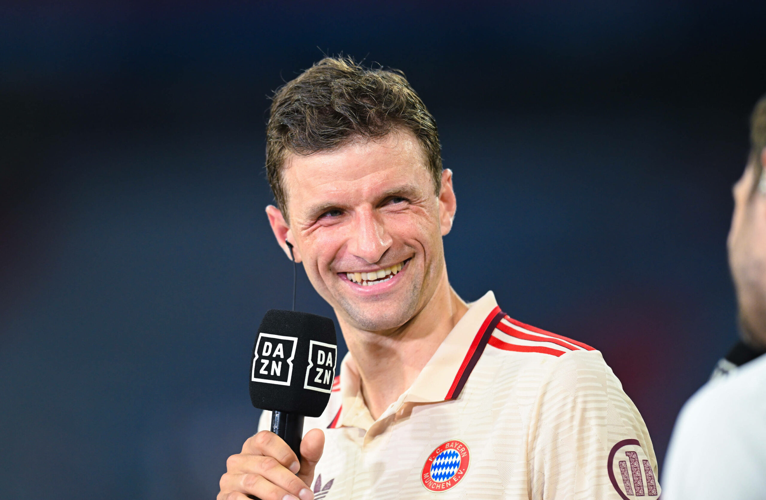 Thomas Müller lacht während eines DAZN-Interviews