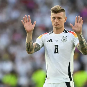 Toni Kroos hebt beide Hände in die Luft.