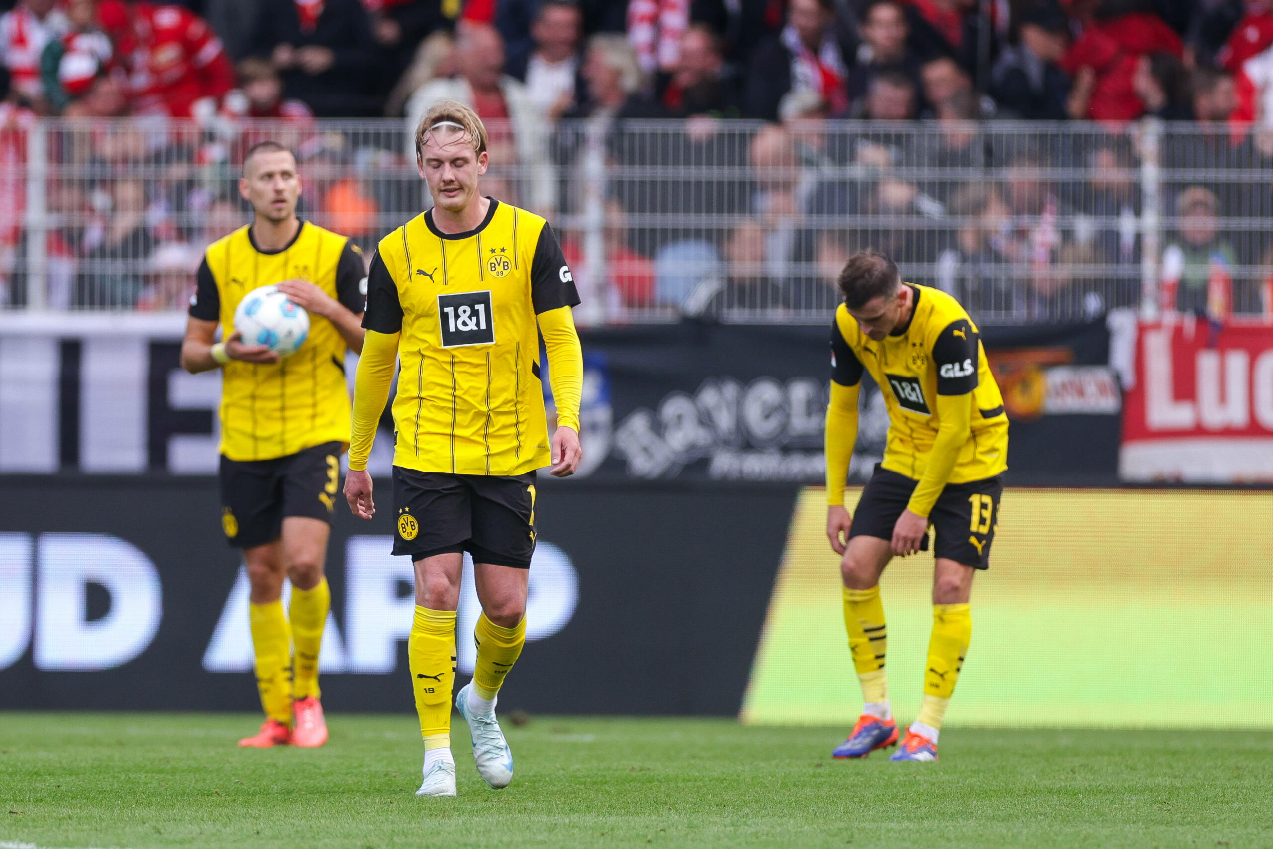 Waldemar Anton, Julian Brandt und Pascal Groß von Borussia Dortmund gucken enttäuscht nach Niederlage gegen Union Berlin