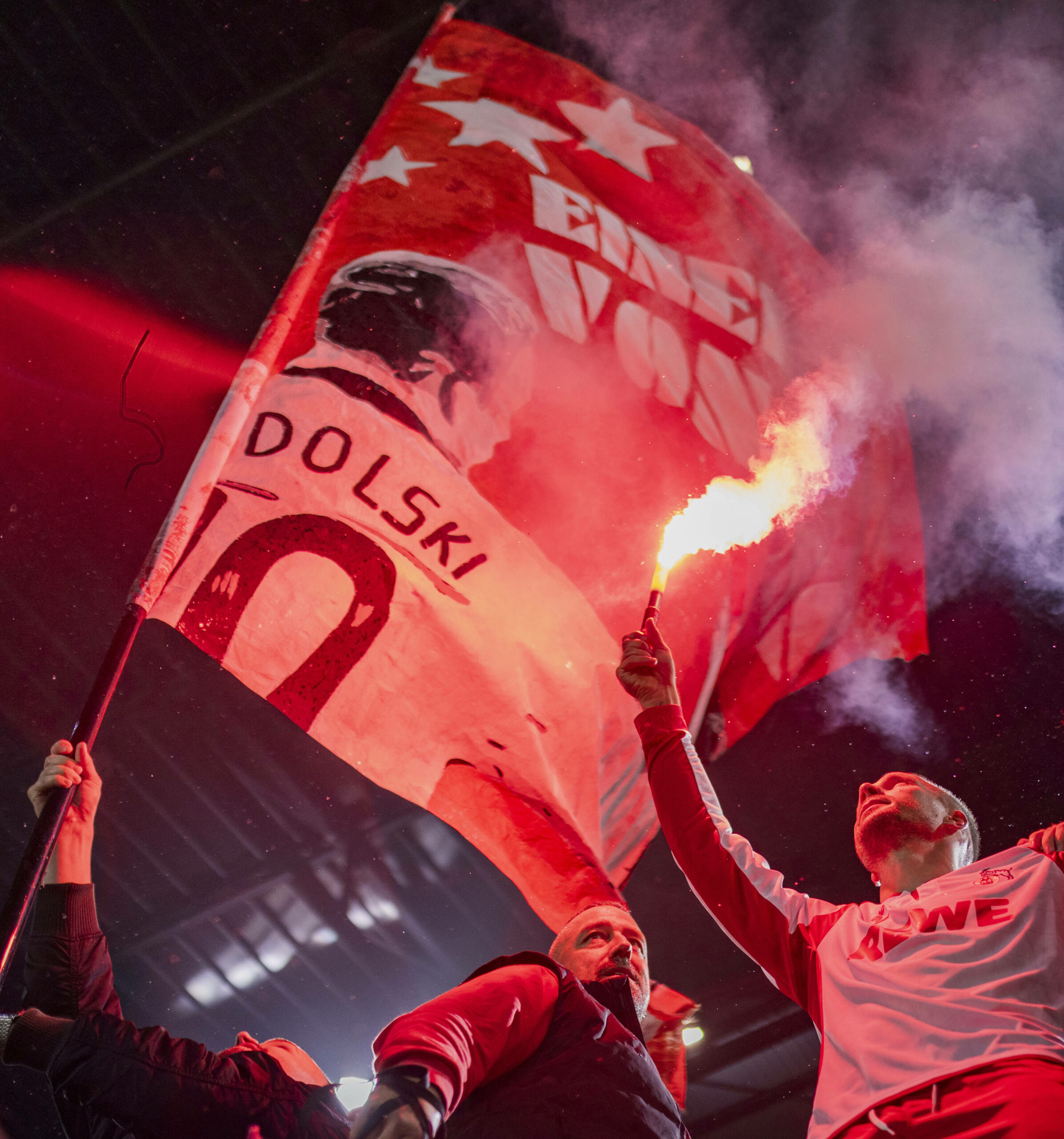 Lukas Podolski hält ein Bengalo in der Hand