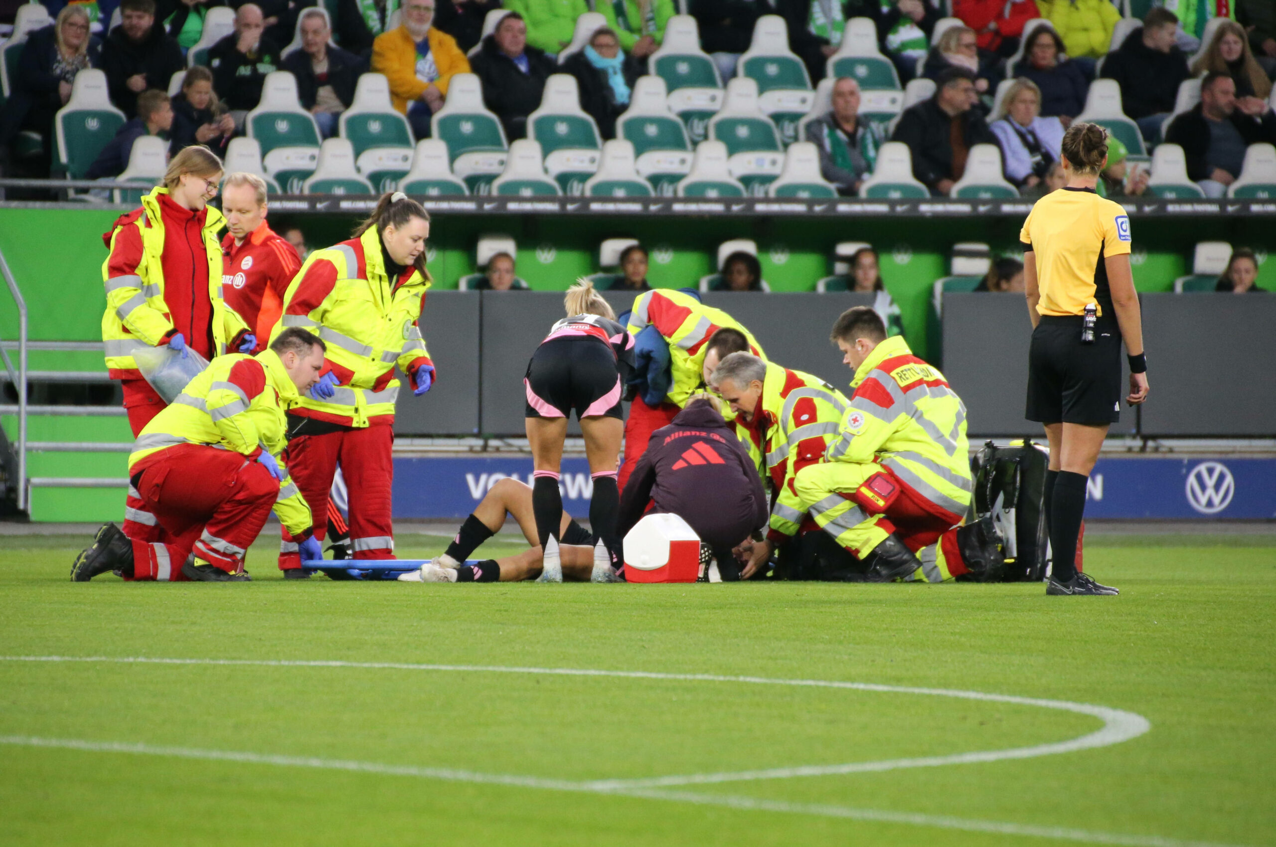 FC Bayern Münchens Jovana Damnjanovic liegt im Spiel gegen den VfL Wolfsburg verletzt auf dem Boden, Sanitäter stehen um sie herum