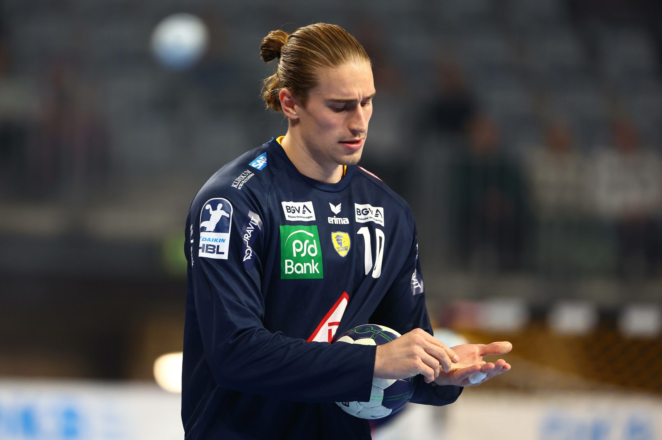 Juri Knorr (Rhein-Neckar Löwen) guckt im Spiel gegen den HSV Hamburg zu seinem verletzten Finger