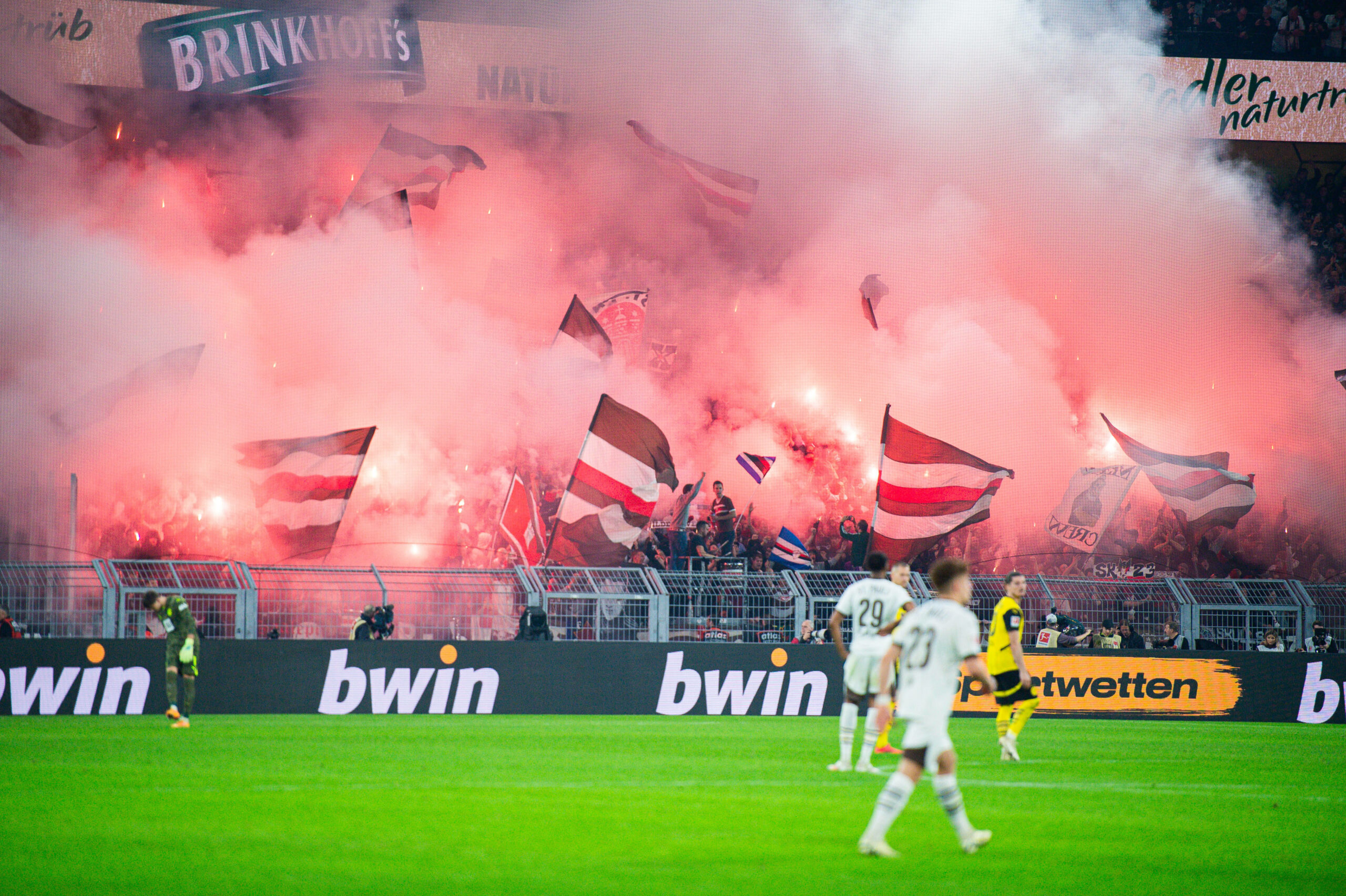 Fans im Block des FC St. Pauli brennen Pyrotechnik während des Spiels gegen Borussia Dortmund ab