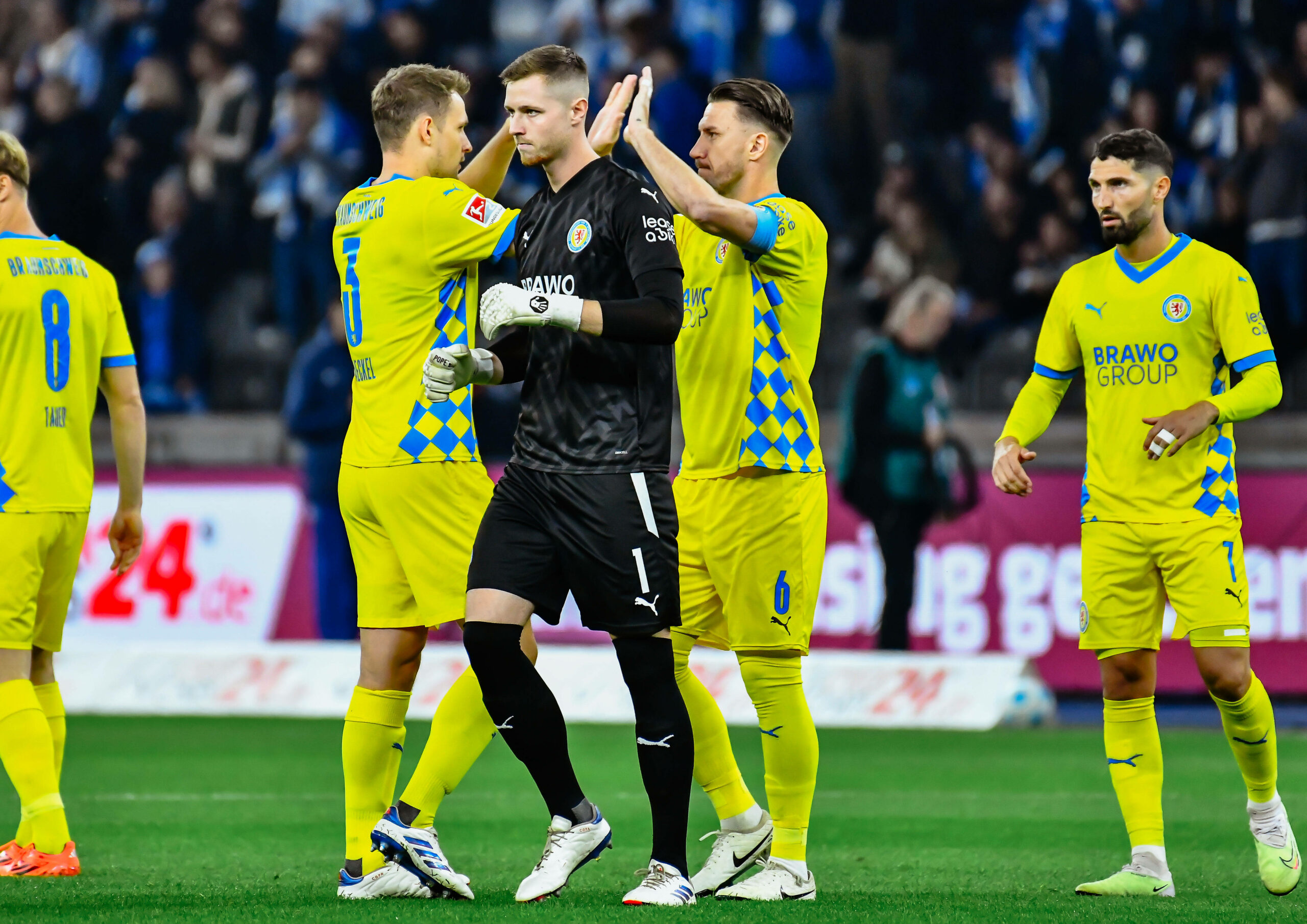 Lennart Grill geht enttäuscht über den Platz, Spieler der Eintracht Braunschweig klatschen sich im Hintergrund ab